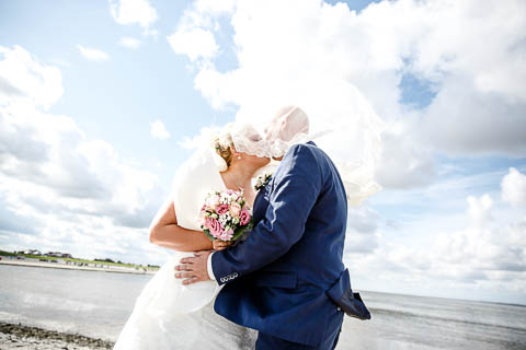 Brautpaar küssend im Wind
